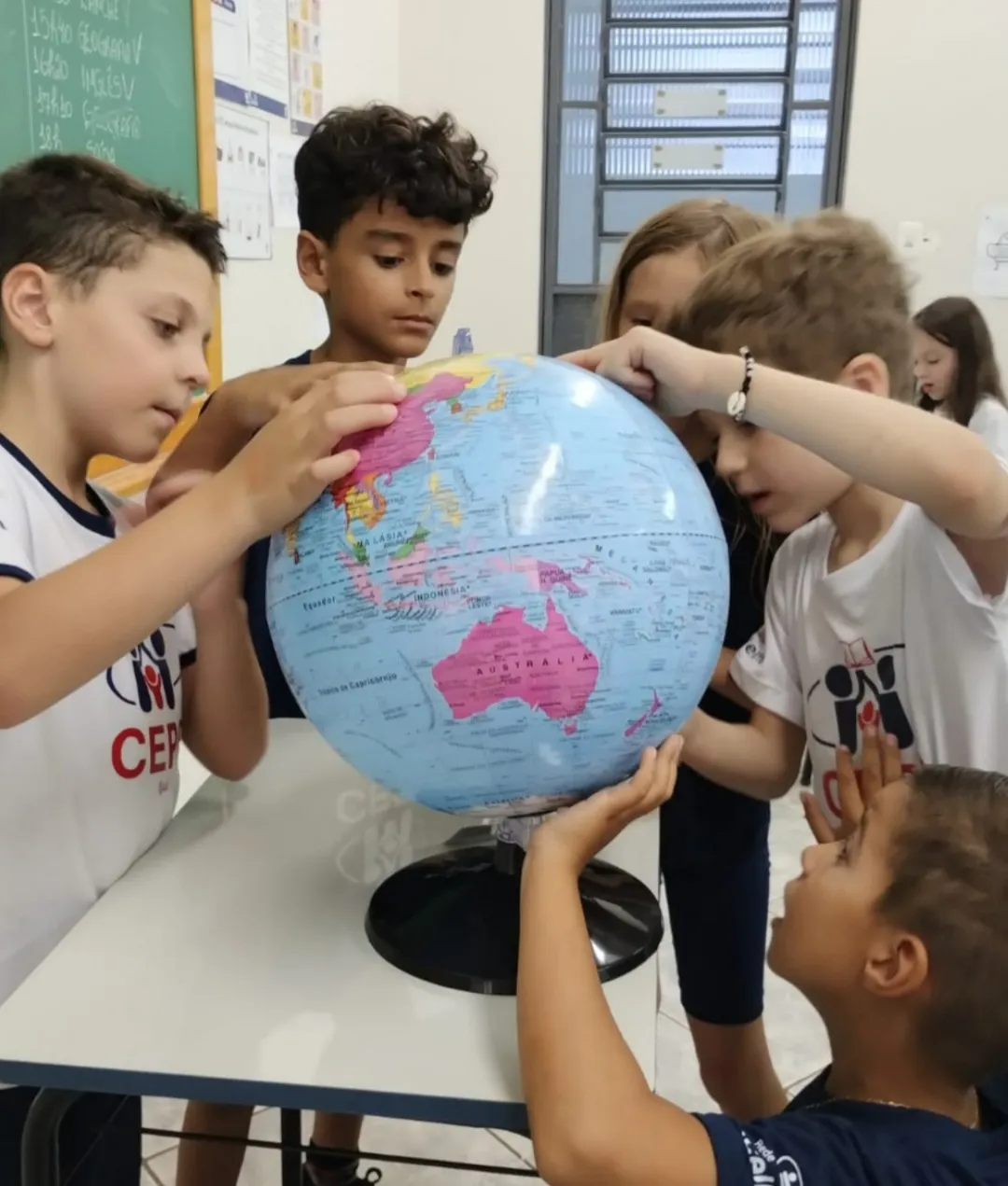 Alunos do CEPP observando um globo terrestre durante uma atividade